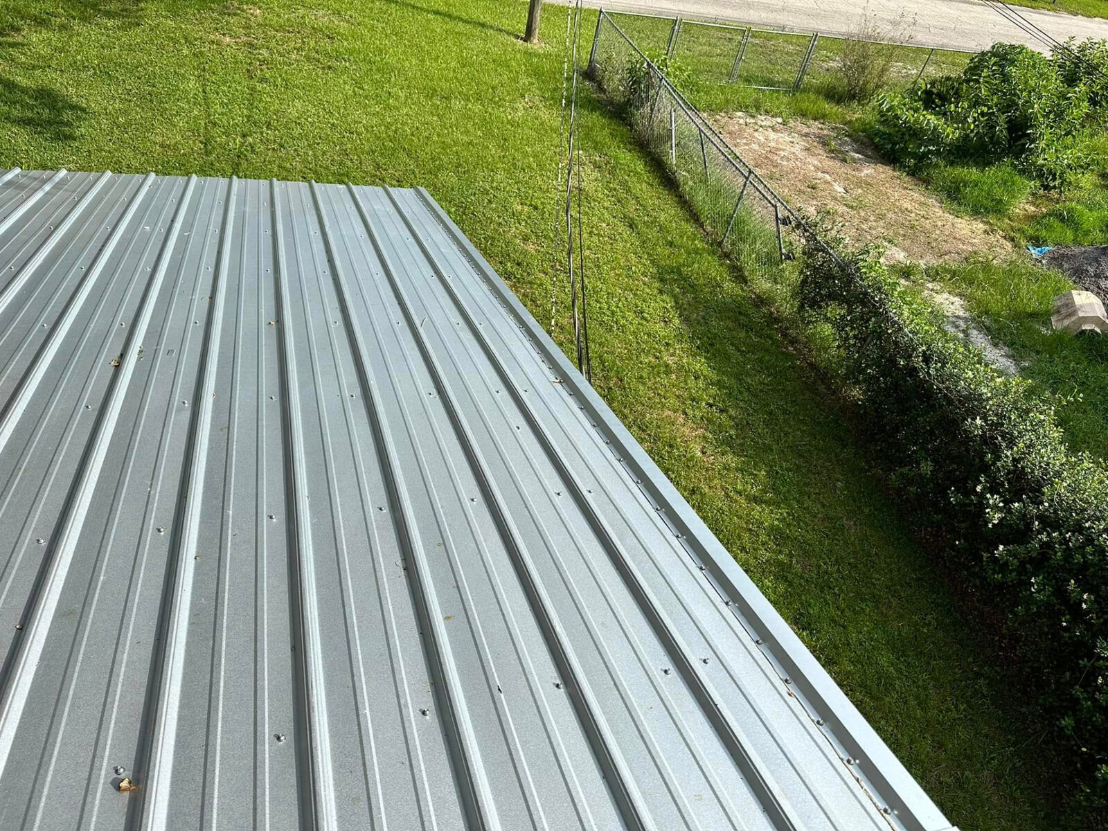 Metal roof panels and rake trim along a grassy side yard