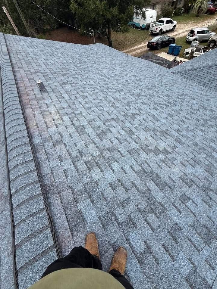 Newly installed light gray architectural shingle roof with a ridge vent